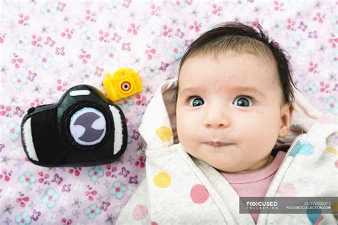 Portrait Of Baby Girl Lying On Bed With Two Toy Cameras — Toys Indoor