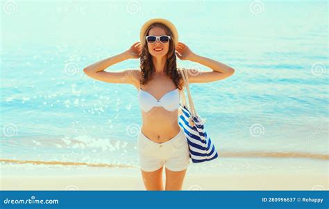 夏日假期，海岸海岸背景沙滩上，穿着比基尼泳装、戴着草帽、带袋子的微笑美女 库存图片 图片 包括有 帽子 诱饵 280996637