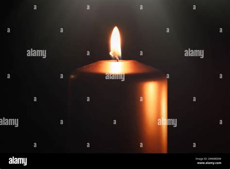 Funeral symbol with burning candle in darkness. Memorial composition