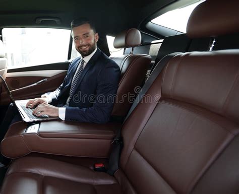 Smiling Businessman Sitting In The Back Seat Of A Prestigious Ca Stock