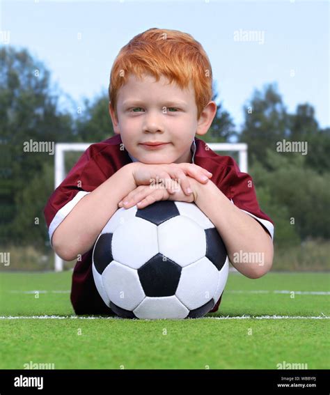 Niñito Alegre Con Jengibre Pelo Posando Con Un Balón De Fútbol Retrato