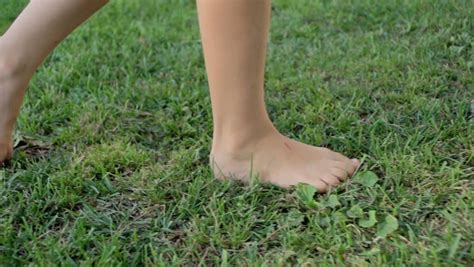 Slow Motion Shot Of A Girls Bare Feet Walking Over Green Grass Field Stock Footage Video