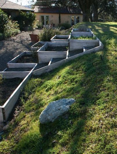 An Outdoor Garden With Raised Planters And Rocks In The Grass Next To