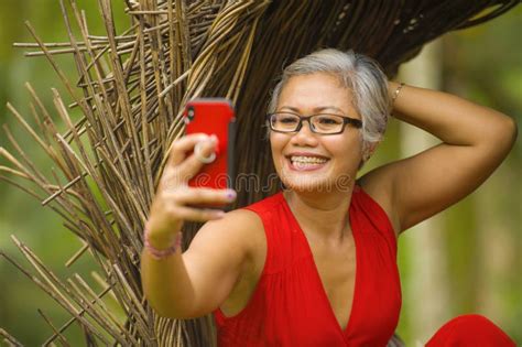 Attractive And Happy Middle Aged 40s Or 50s Asian Woman With Grey Hair And Stylish Dress Taking