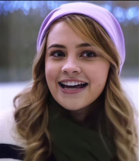 A Close Up Of A Person Wearing A Purple Headband And Smiling At The Camera