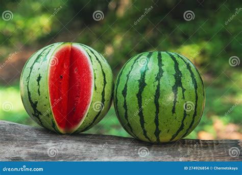 Delicious Whole And Cut Watermelons On Log Outdoors Stock Photo Image
