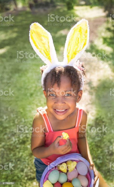 Cute African American Girl Eating And Enjoying Easter Candy Wearing