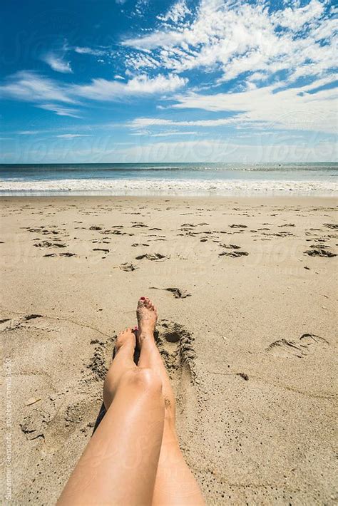 Woman Sunbathing Alone On The Beach By Stocksy Contributor Skc