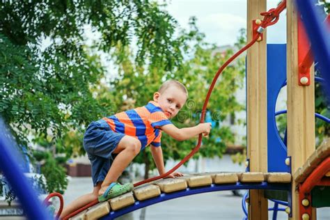 Cute Little Boy Playing On The Playground In The Summer Stock Photo