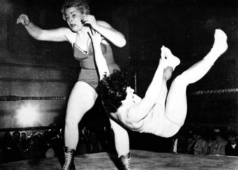 two women are wrestling in an old black and white photo