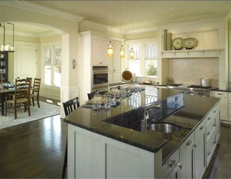This kitchen has an interesting design with two islands. A 2 tiered kitchen island shields a cooking mess from ...