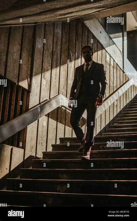 Serious Businessman With Sunglasses Walking Down The Dark Stairs With