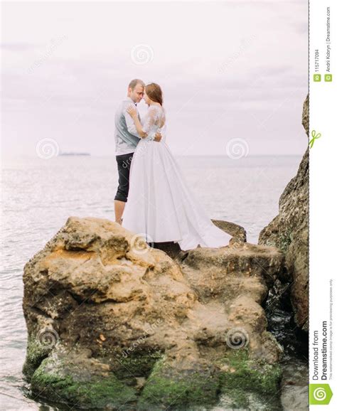 Lovely Outdoor Portrait Of The Newlyweds Standing Head To Head On The