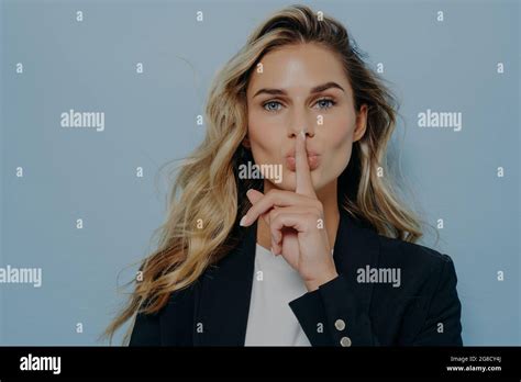 Blonde Woman Making Shush Gesture With Her Hand Stock Photo Alamy