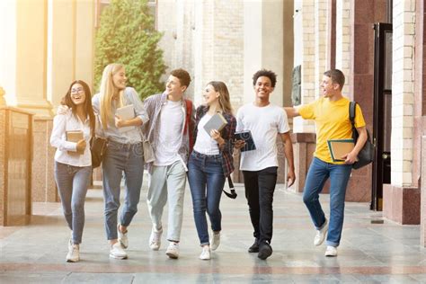 Happy Students Walking Together In Campus Having Break Stock Photo