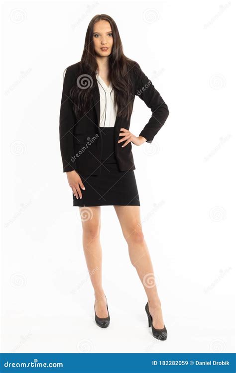 a businesswoman is standing in a black classic suit and rests her hand on her hip stock image