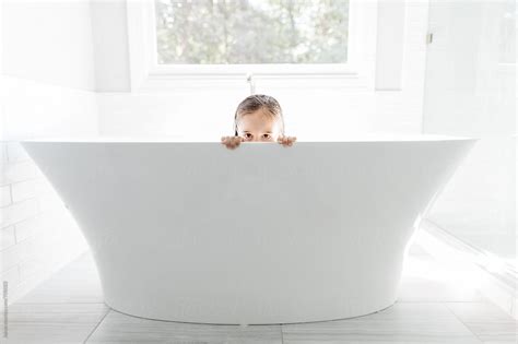 A Beautiful Young Girl Peeking Out From A Large Bathtub By Stocksy Contributor Jakob