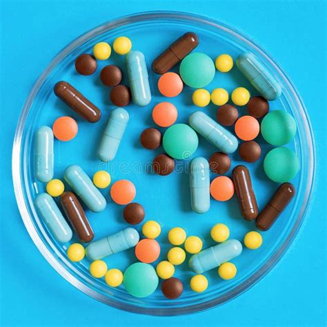 Colorful Pills In The Glass Container On Blue Background Stock Image