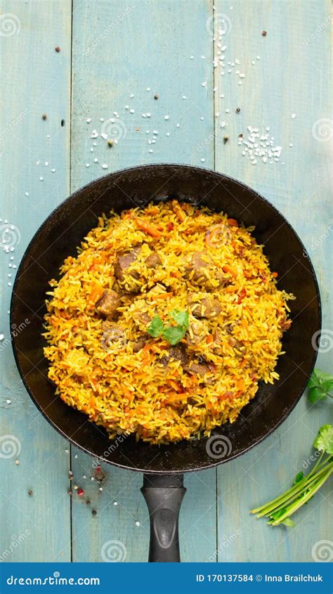 Dish Of Oriental Cuisine Pilaf With Lamb In A Pan On A Wooden