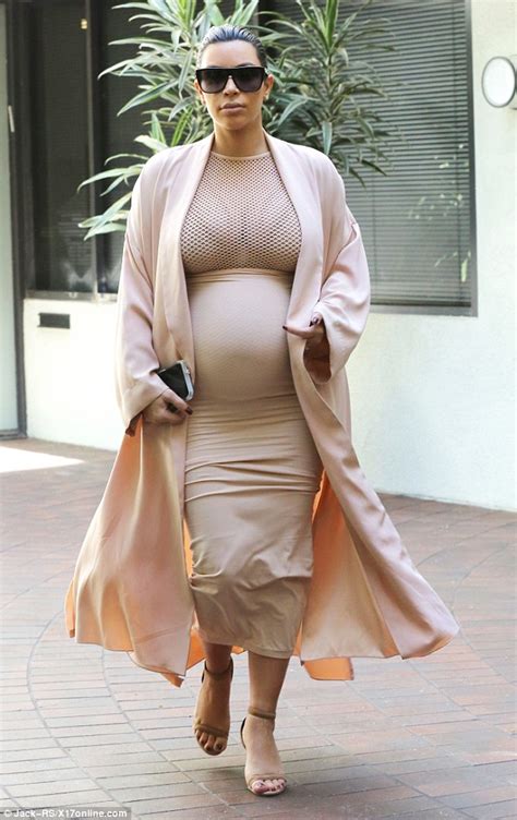 kim kardashian shows her pregnant figure in skirt and net top beneath a flowing robe daily