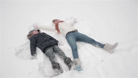 Two Kids In Winter Making Snow Angels Stock Footage Video