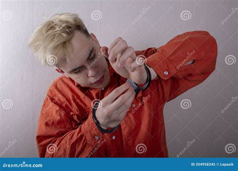 A Juvenile Delinquent Tries To Open The Handcuffs With A Paper Clip