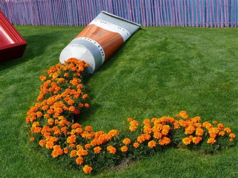 A Flower Bed In The Shape Of A Rocket On Top Of Grass With Flowers