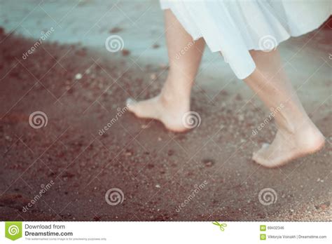 Young Woman In White Dress Walking Alone On The Beach
