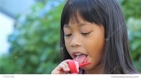 Smiling Asian Girl Enjoys A Popsicle Close Up Stock Video Footage