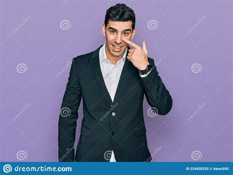 Handsome Hispanic Man Wearing Business Clothes Pointing With Hand Finger To Face And Nose