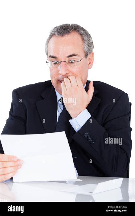 Portrait Of Shocked Mature Businessman Looking At Document Stock Photo