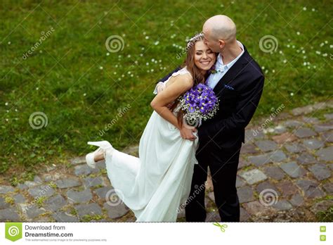 Groom Kisses Bride S Forehead While She Leans To Him Smiling Stock