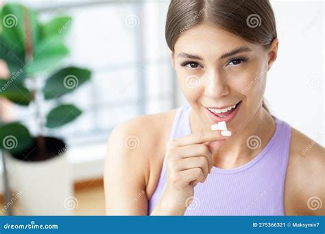 Closeup Detail Of Woman Putting Pink Chewing Gum Into Her Mouth Stock