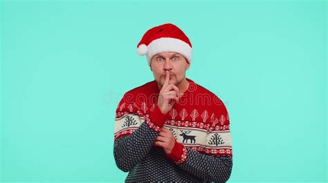 Man Wears Red Christmas Sweater Presses Index Finger To Lips Makes