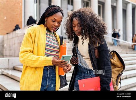 Stock Photo Of Black Female Students Talking And Using Phone Outside