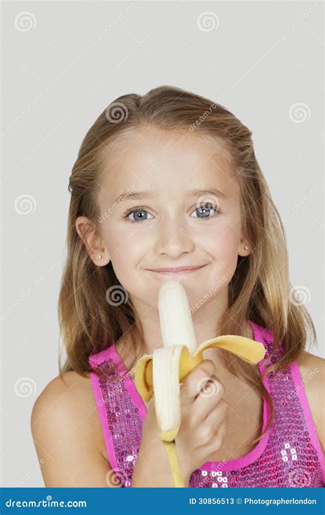 Portrait De Jeune Fille Tenant La Banane Sur Le Fond Gris Image Stock