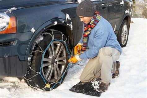 Man Putting Snow Chains Onto Tyre Of Car Stock Image Colourbox