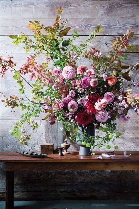 A Vase Filled With Lots Of Flowers Sitting On Top Of A Wooden Table