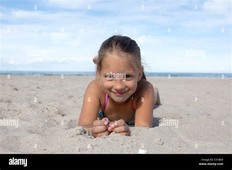Portrait Of Young Girl Lying In Sand On Beach Stock Photo Alamy