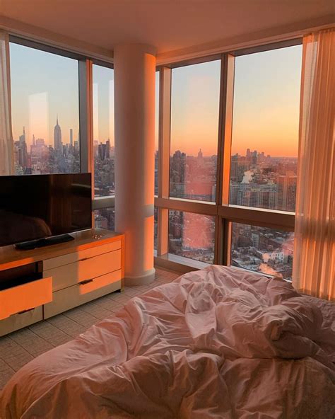 A Bedroom With A Large Window Overlooking The City