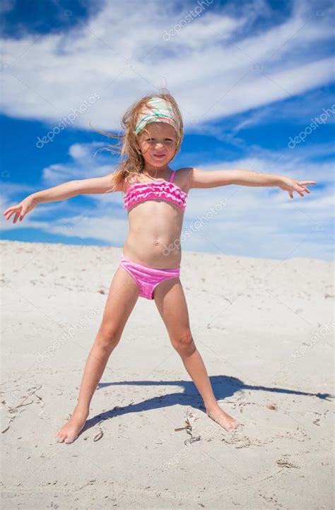 Очаровательны маленькая девочка в красивых купальниках повеселиться на тропическом пляже
