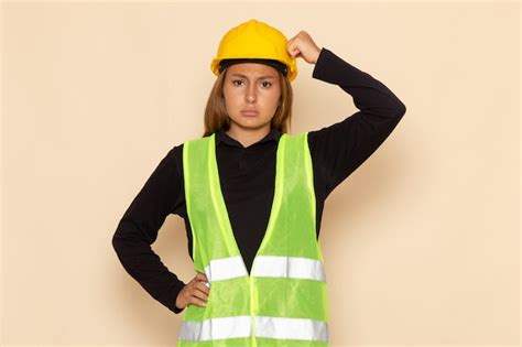 Free Photo Front View Female Builder In Yellow Helmet With Confused Expression On The White Wall