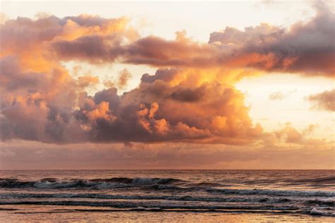 Fluffy Sunset Clouds Above Waves · Free Stock Photo