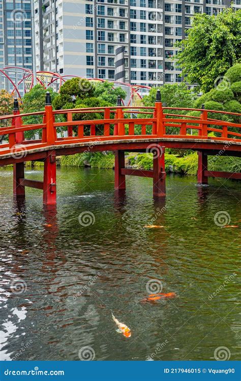 Red Wooden Bridge Across The Koi Fish Pond In Japanese Garden Stock