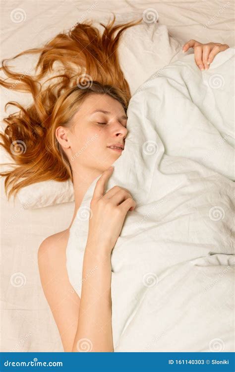 hermosa mujer sonriente descansando en el dormitorio bajo una manta imagen de archivo imagen