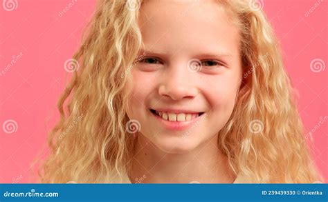 Close Up Portrait Of Blonde Teenage Girl Looks Into Camera And Smiles Waves Her Hair Against