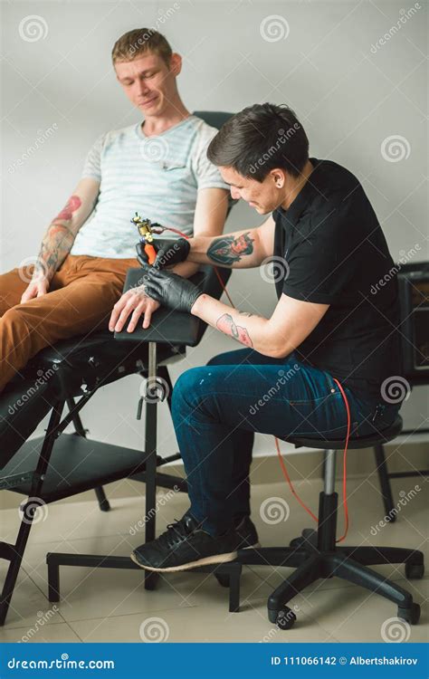 L Artista Matrice Del Tatuaggio In Guanti Fa Il Tatuaggio Fotografia Stock Immagine Di Filtro