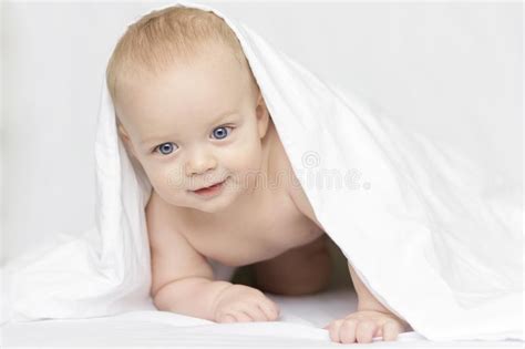 Cute Smiling Baby Boy Looking At Camera Under A White Blanket Or Towel