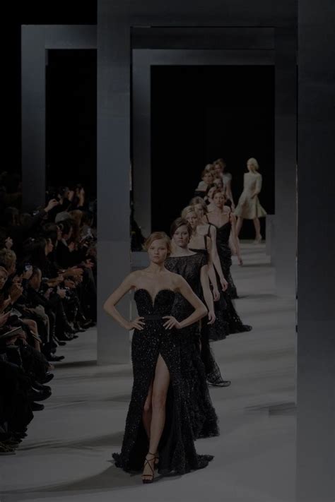 Models Walk Down The Runway In Black Gowns