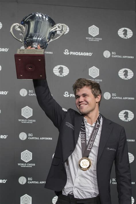 Magnus Carlsen Of Norway Smiles As He Holds Up His Championship